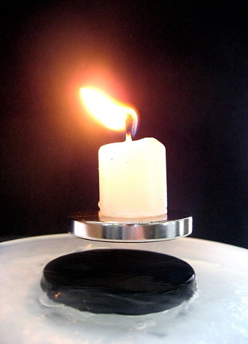 A candle, levitated on a magnet, above a superconductor