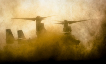 A U.S. Marine MV-22B Osprey landing in a dust cloud